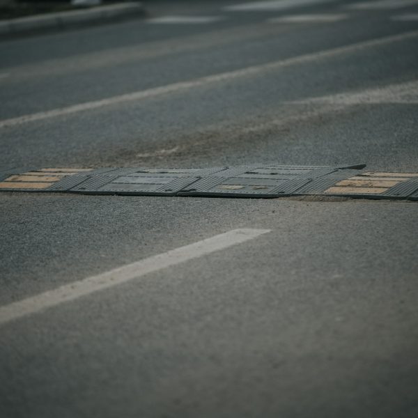 Closeup shot of a bolted down traffic safety speed bump on an asphalt road
