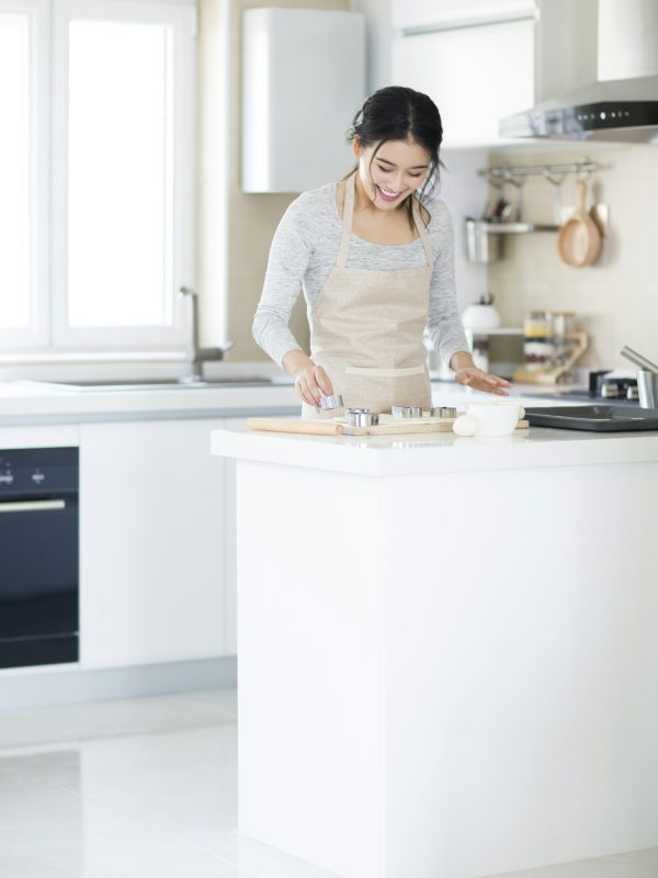 Young woman making cookies in kitchen
